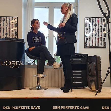 Gruppe af mennesker der hygger sig udendørs med makeupudstyr og festlig stemning