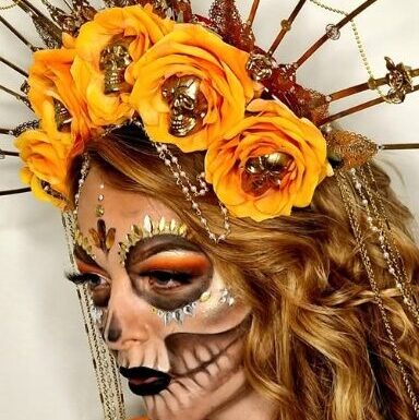 Kreativ Día de los Muertos makeup med detaljeret sugar skull-design, blomsterkrans og kunstnerisk håropsætning
