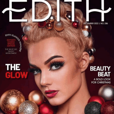 kvinde med dramatisk øjenmakeup, glødende hud, opsat hår og juleinspirerede dekorationer på mørk magasinforside