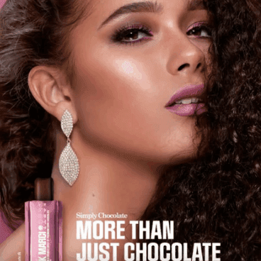 kvinde med glam makeup, glødende hud, markerede øjne og voluminøst krøllet hår i beauty-annoncestil