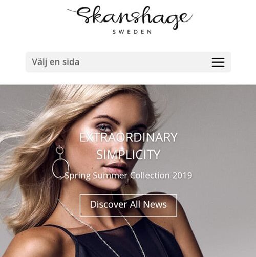 Model med glam makeup, løst bølget hår og smykker på en kommerciel modeside.