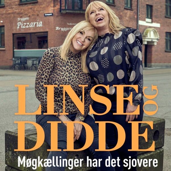 To kvinder linse og didde sidder tæt sammen på en bænk og smiler på en bogforside med stor orange titeltekst