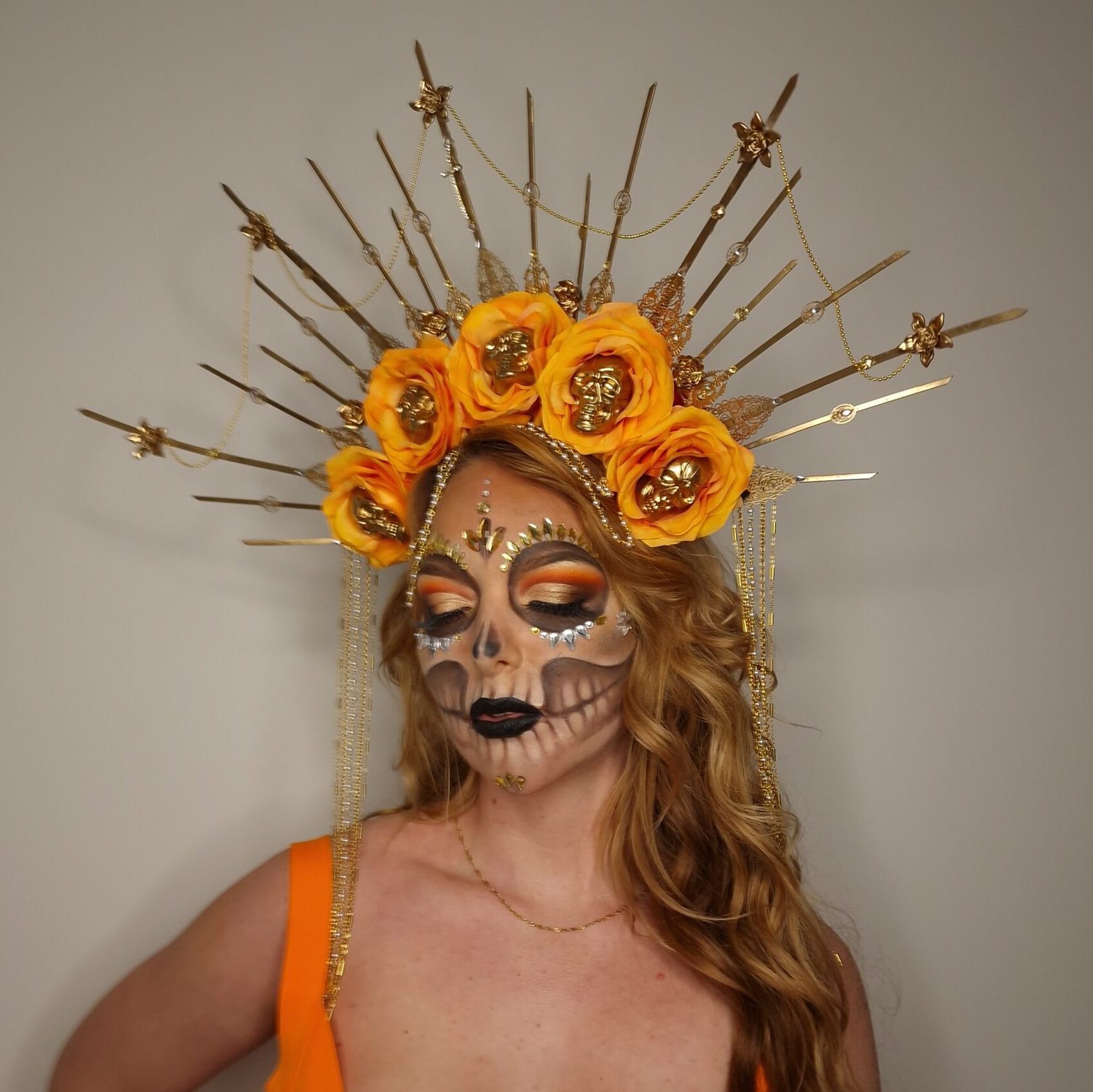 Kreativ Día de los Muertos makeup med detaljeret sugar skull-design, blomsterkrans og kunstnerisk håropsætning
